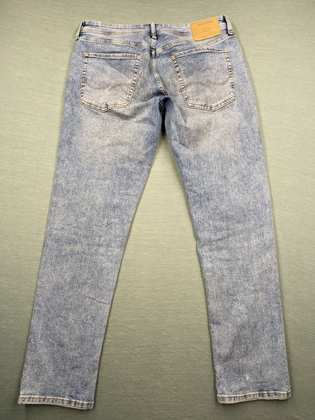 Jack & Jones blue slim fit jeans with button fly and light wash denim texture.