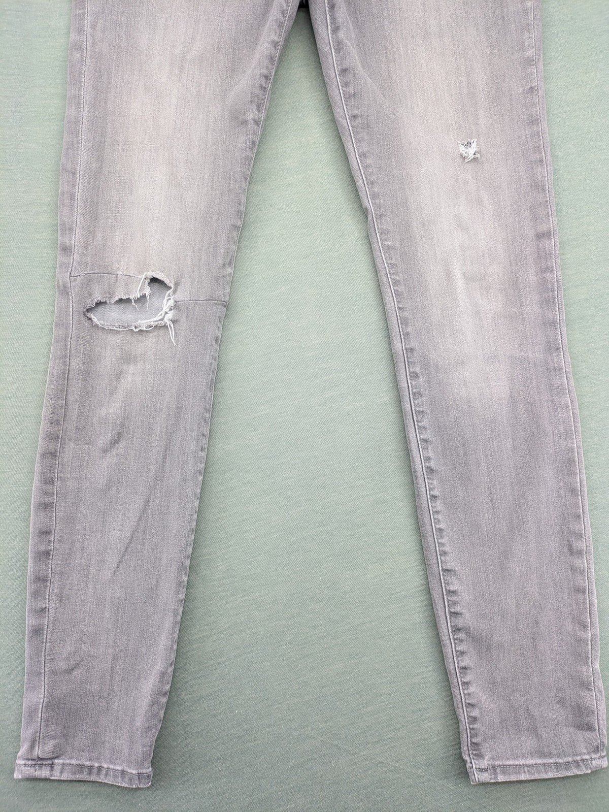 H&M grey super skinny jeans with distressed knee details and low waist fit.