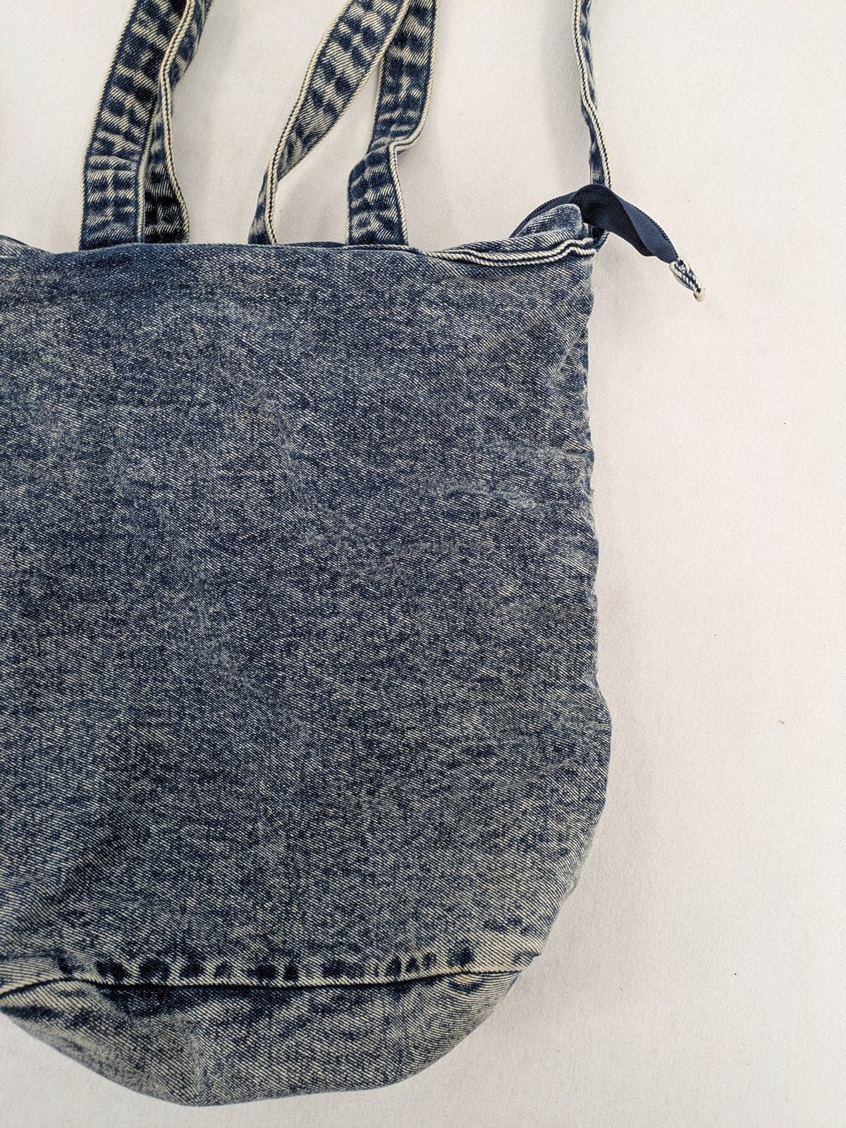 Clockhouse blue acid wash denim tote bag with adjustable shoulder strap and classic handles.