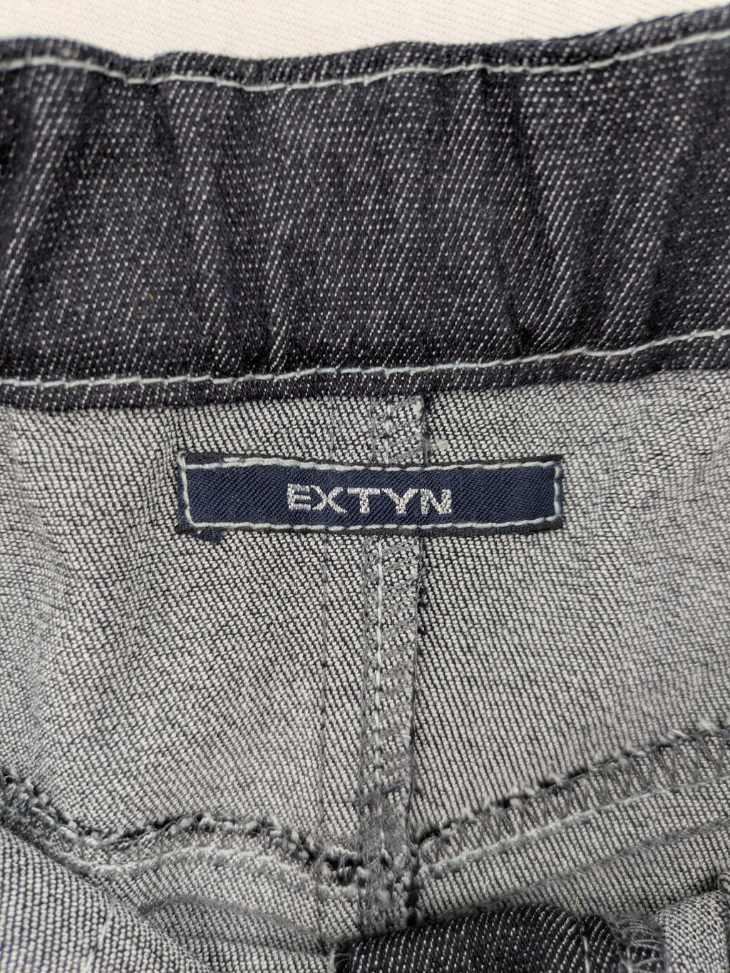 Extyn blue midi skirt with rhinestone dragonfly detail and front slit, stretchy denim fabric.