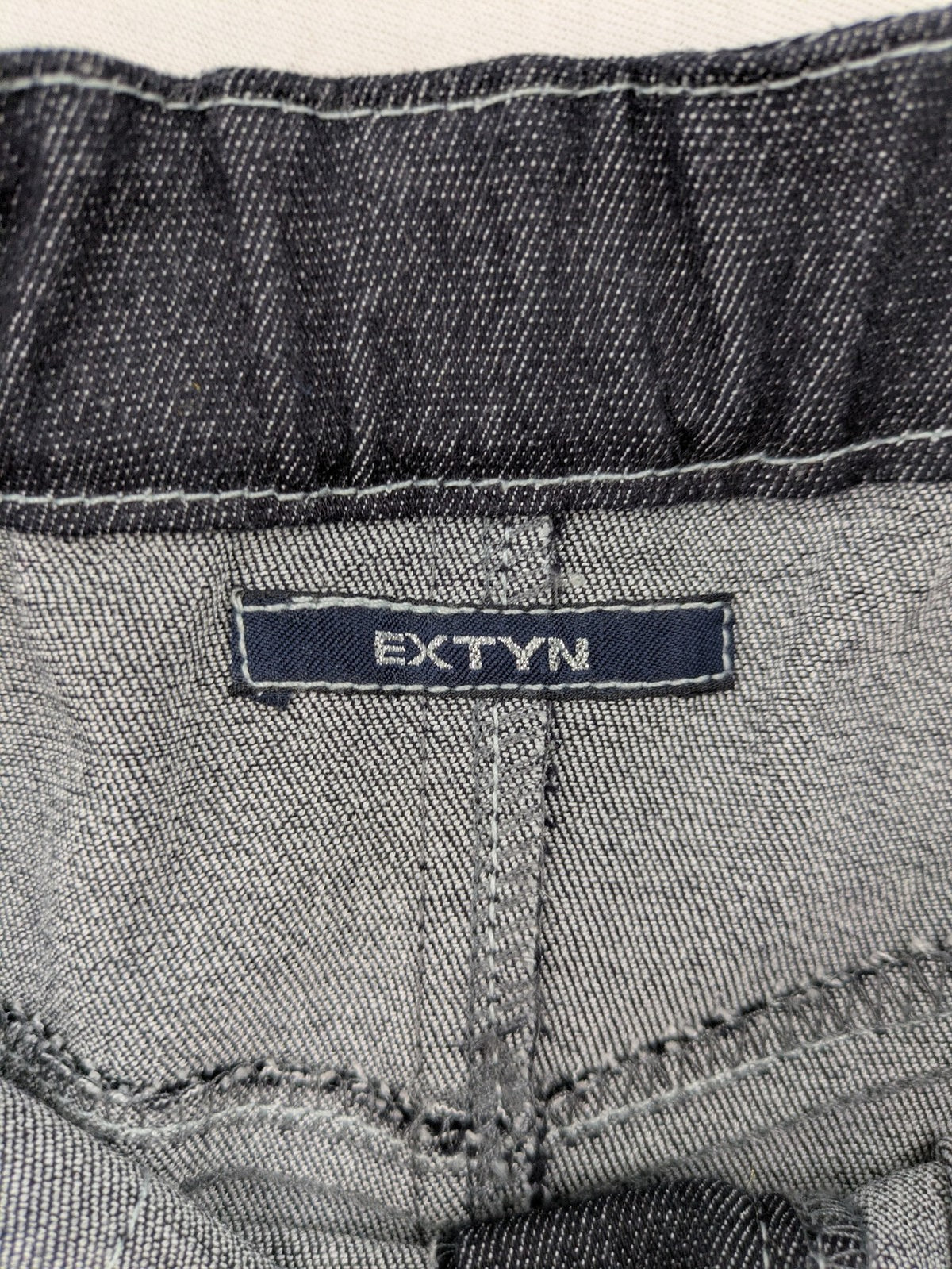Extyn blue midi skirt with rhinestone dragonfly detail and front slit, stretchy denim fabric.