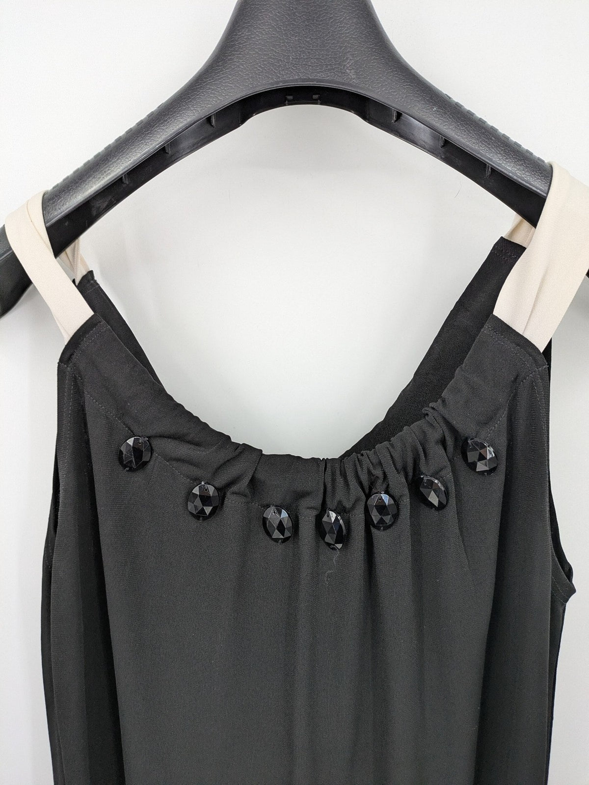 En Focus Studio beige and black top, sleeveless with beaded neckline and tie detail.