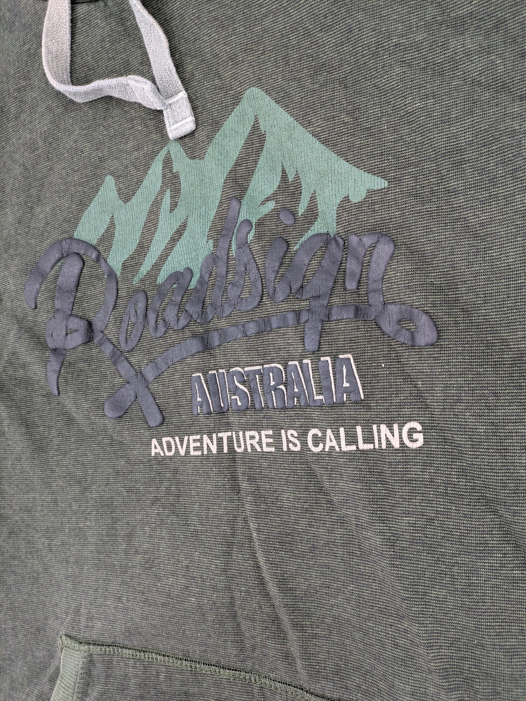 Roadsign Australia green hoodie with mountain graphic print and logo patch on sleeve.