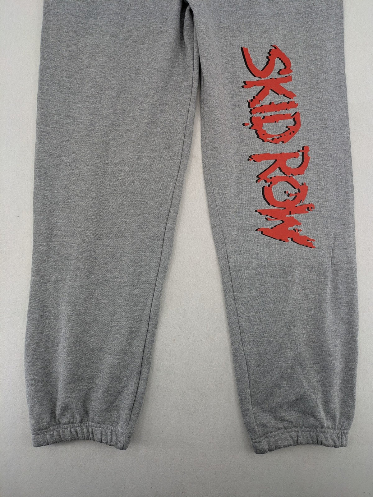 Skid Row grey joggers with red band logo, soft cotton blend, elastic waistband.