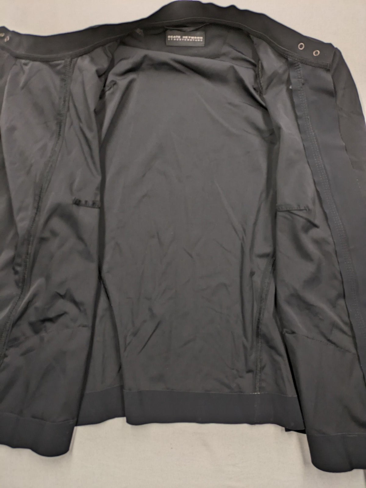 Beate Heymann black biker jacket with asymmetrical front and stand-up collar, stretch material.