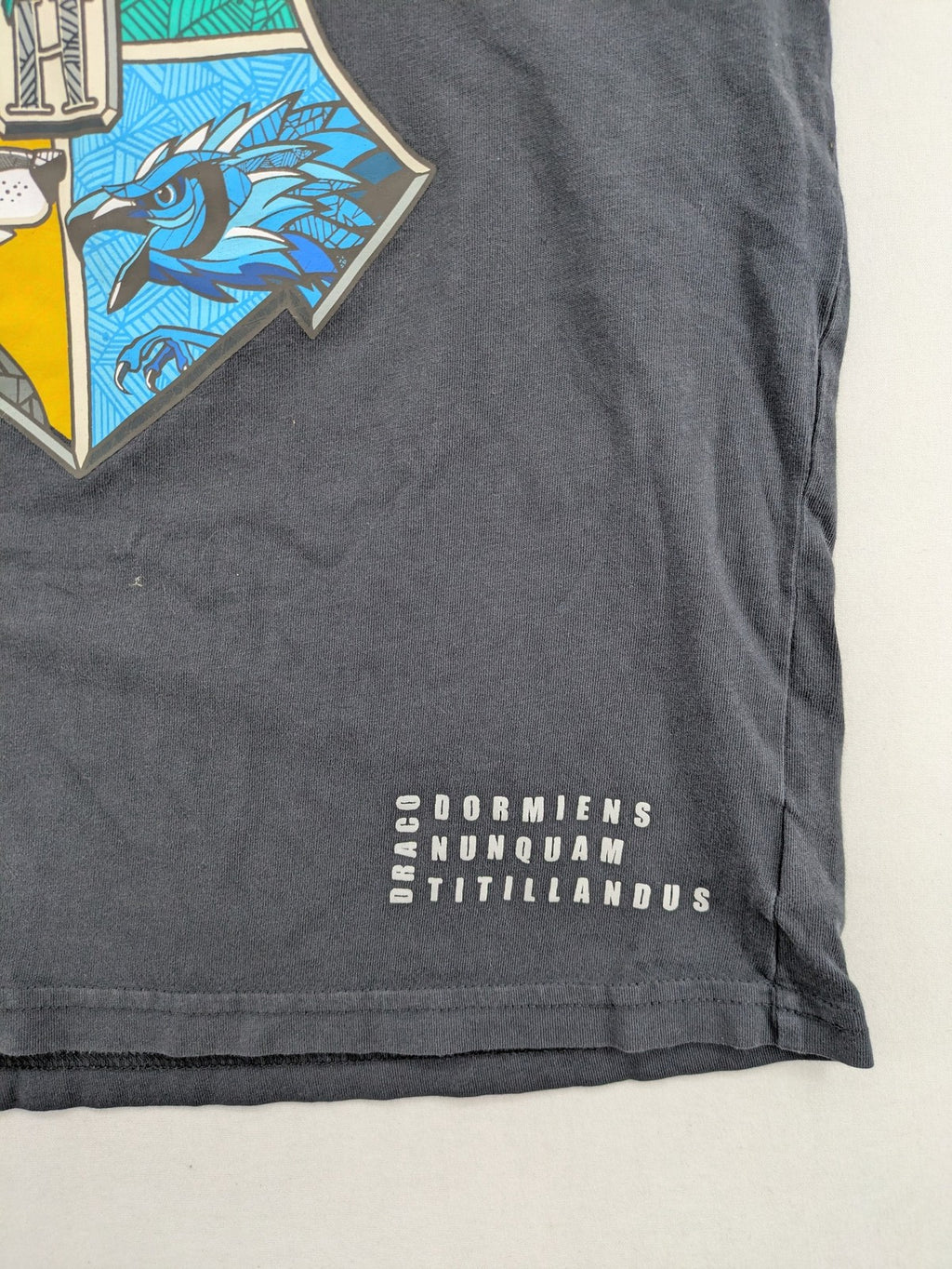 Harry Potter blue t-shirt featuring colorful Hogwarts crest and "I'd Rather Be At Hogwarts" slogan.
