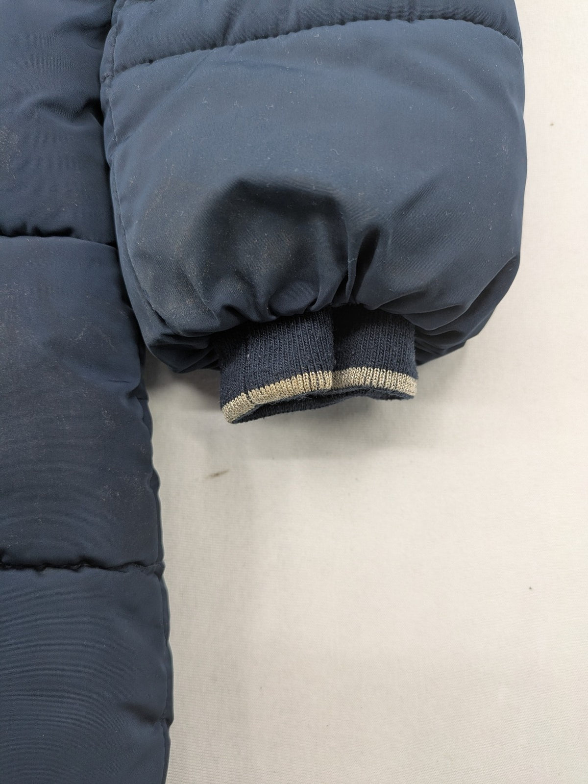 GEF cream coat with quilted design, fleece-lined hood, and faux fur trim.