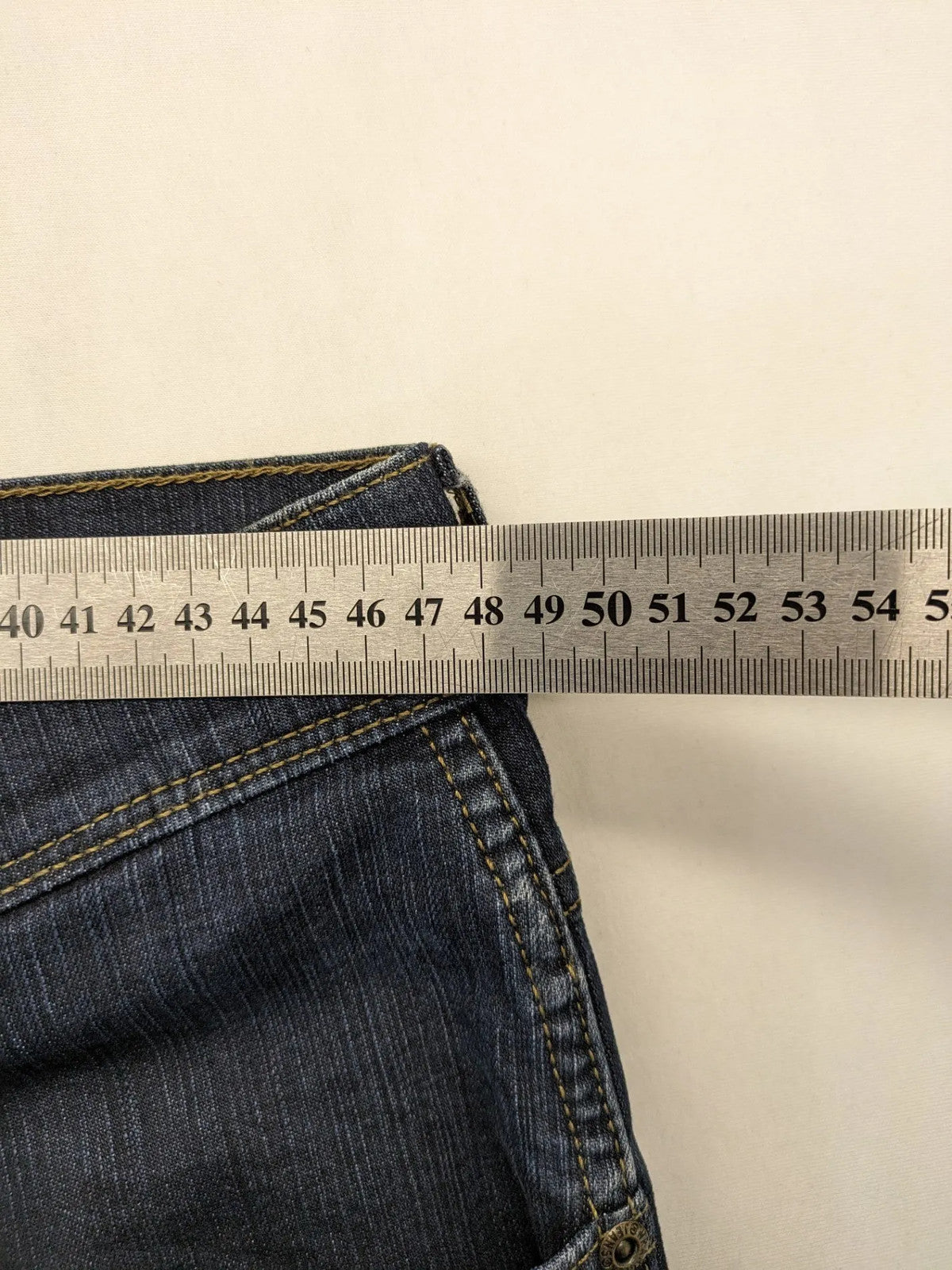Wrangler straight jeans dark blue wash 5-pocket design with zipper, durable cotton blend.