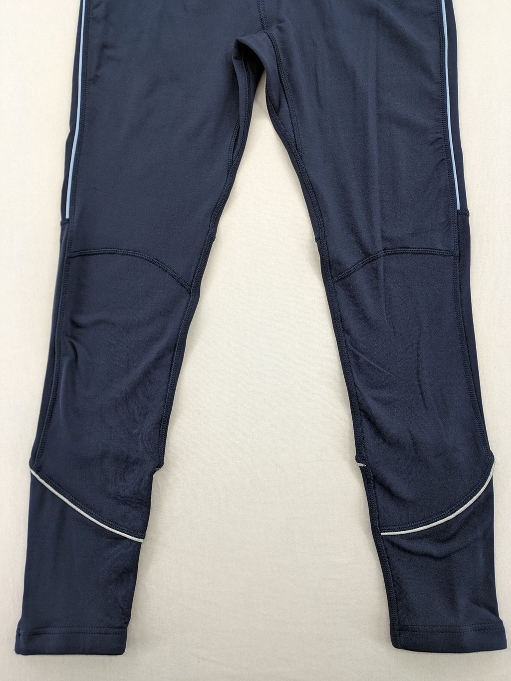 Crane Sports navy running tights with reflective details and zippered ankle openings.