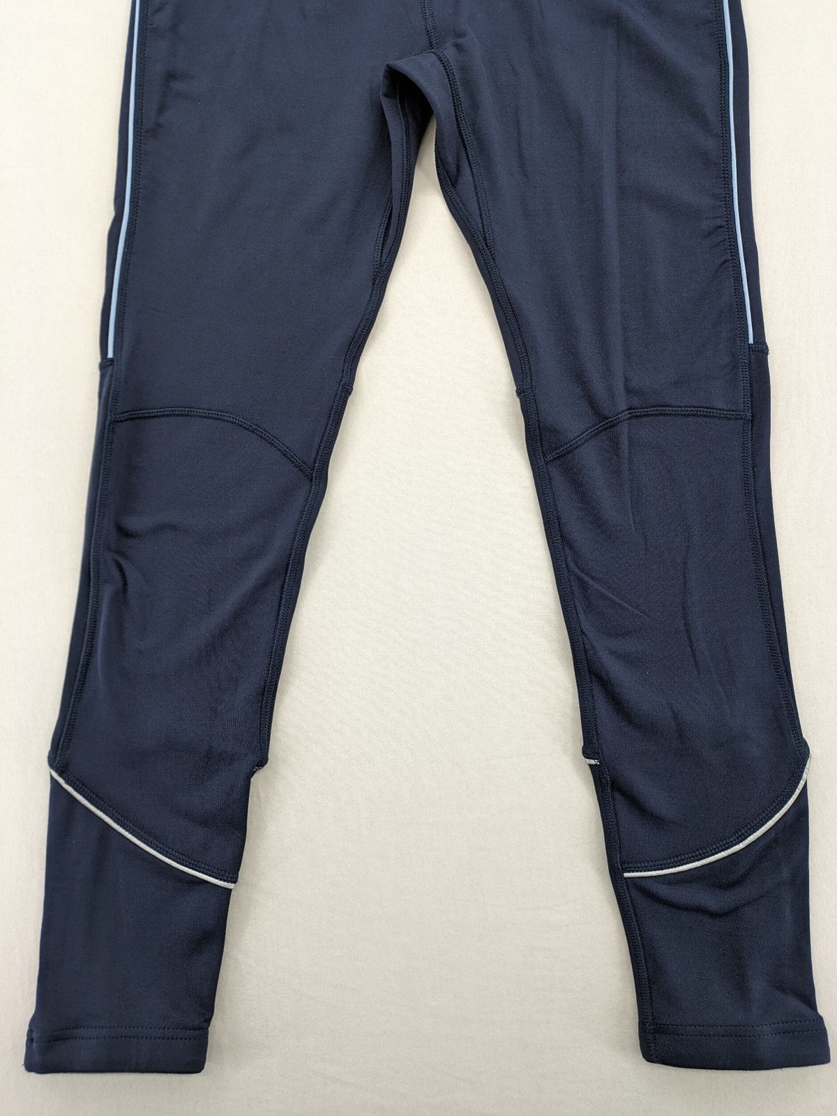 Crane Sports navy running tights with reflective details and zippered ankle openings.