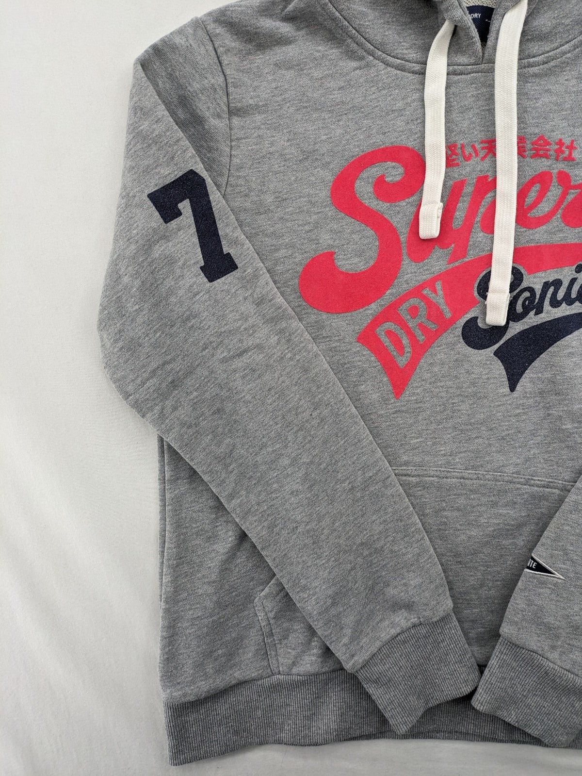 Superdry grey hoodie with Sonics logo, number 7 detail, kangaroo pocket, and drawstring hood.