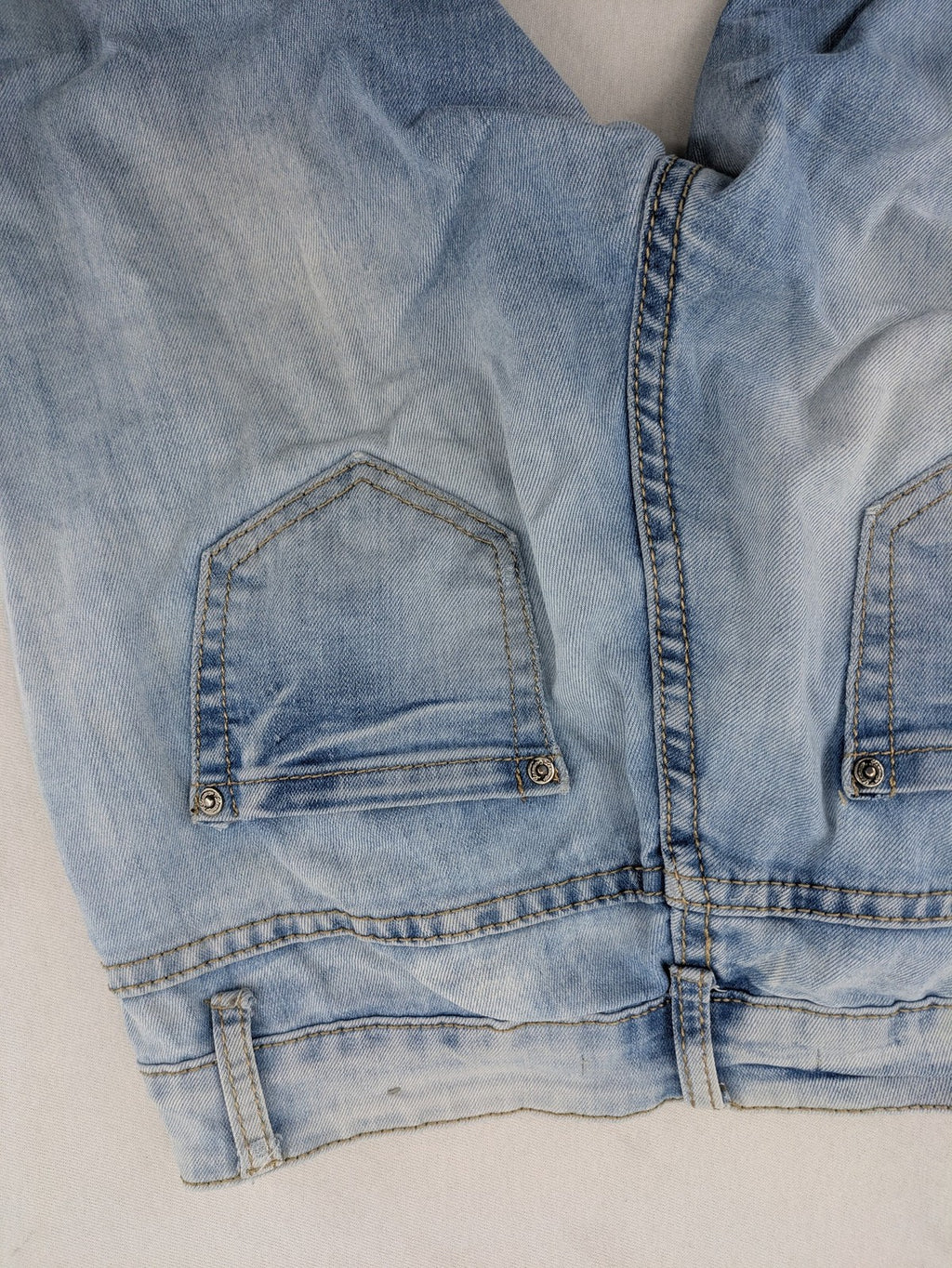 Lexxury blue skinny jeans distressed with knee rips and light wash finish.