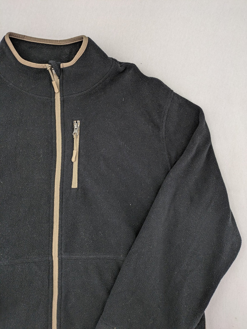 Crane beige and black fleece jacket full zip with cream accents and zippered pockets.
