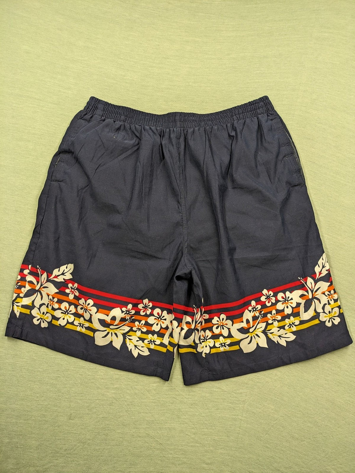 Muster multi swim shorts dark blue with vibrant Hawaii floral pattern and elastic waistband.