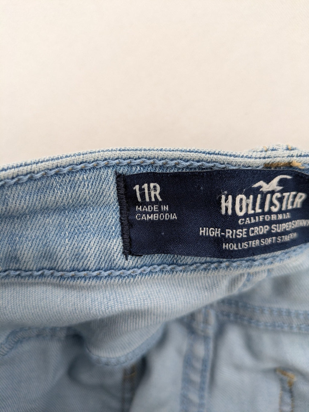 Hollister blue high-rise crop super skinny jeans with distressed rips and frayed hem.