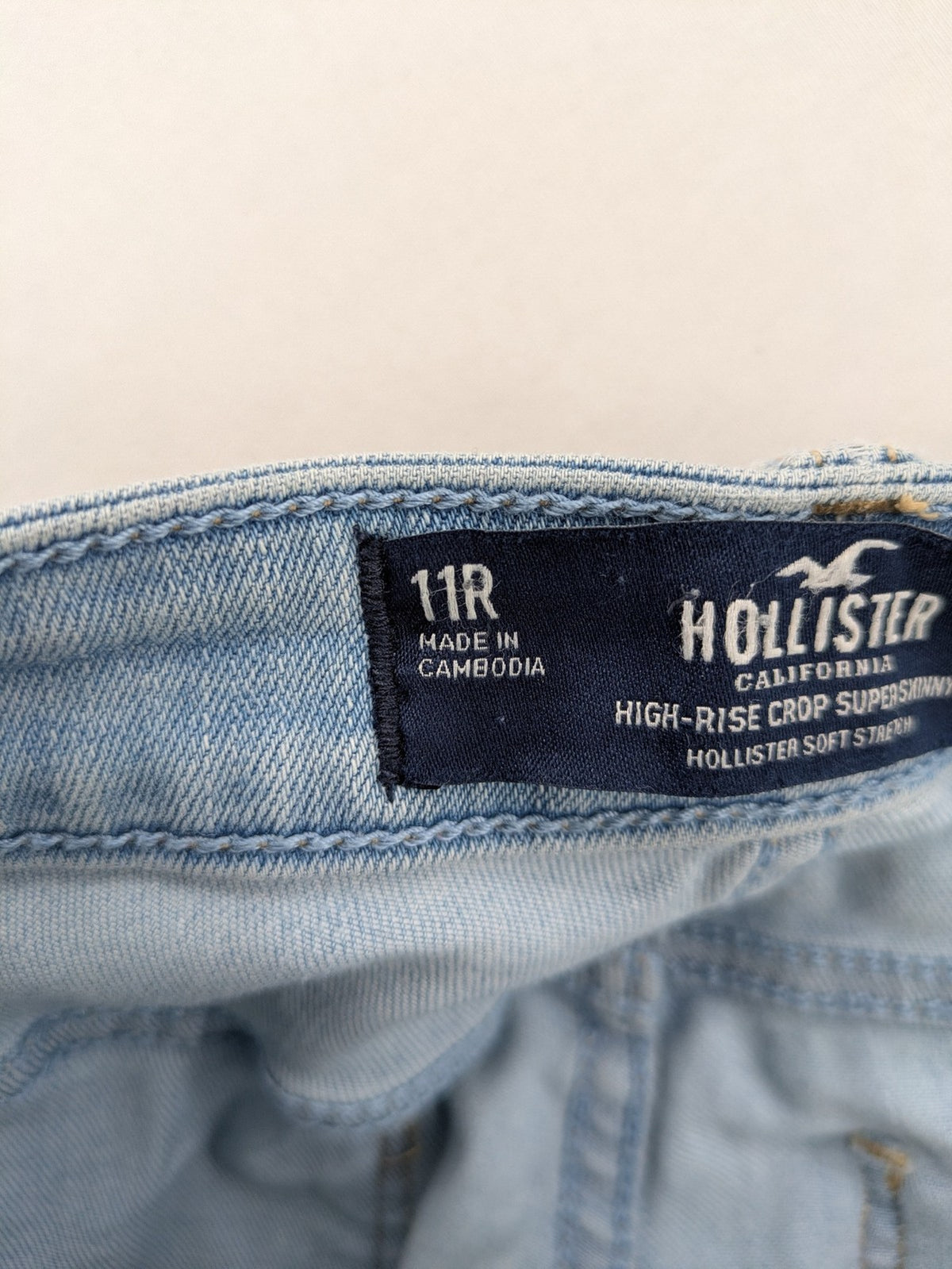 Hollister blue high-rise crop super skinny jeans with distressed rips and frayed hem.