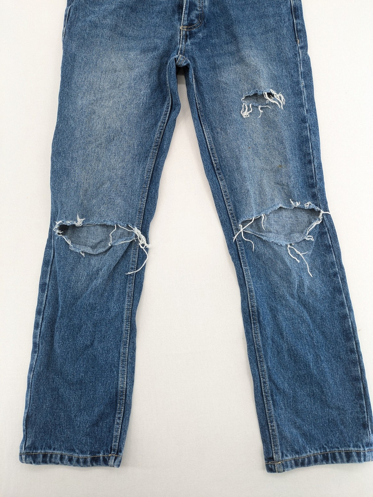 FSBN blue straight jeans with distressed knee rips and classic button fly.