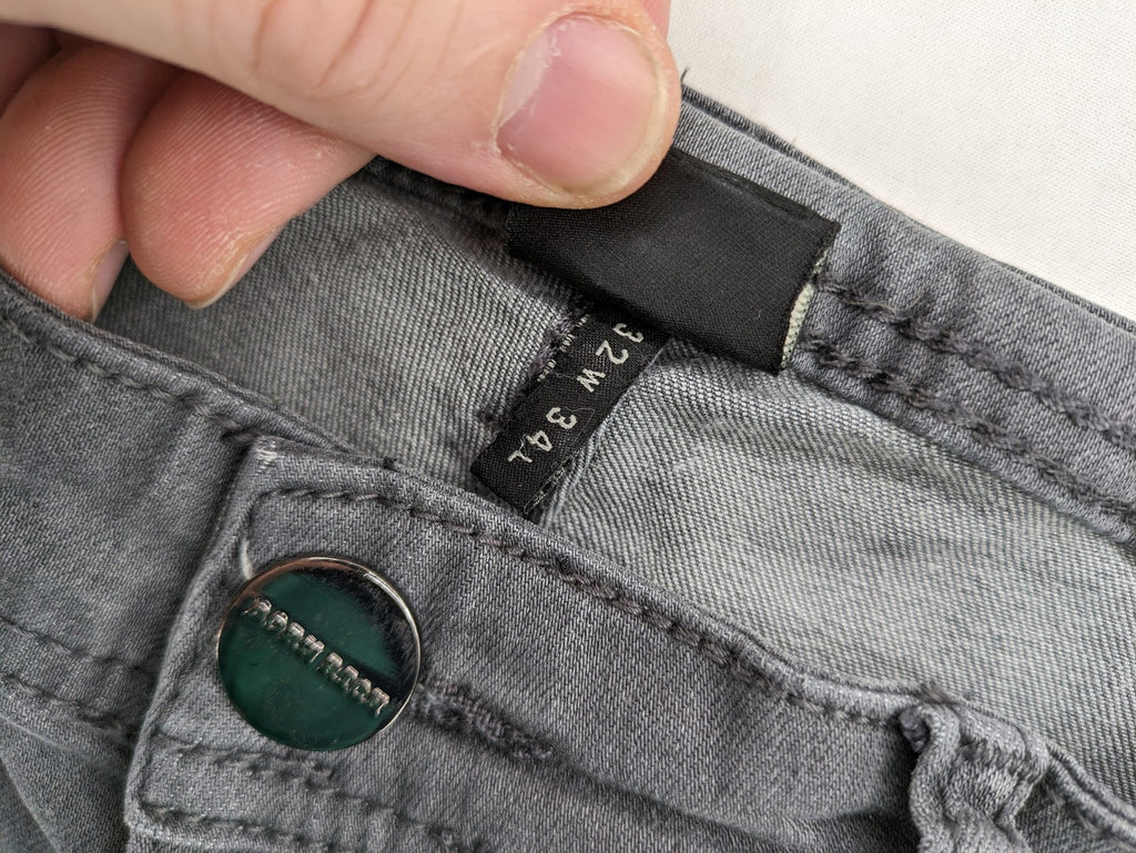 Born Rich grey slim fit jeans with button fly and washed denim texture.