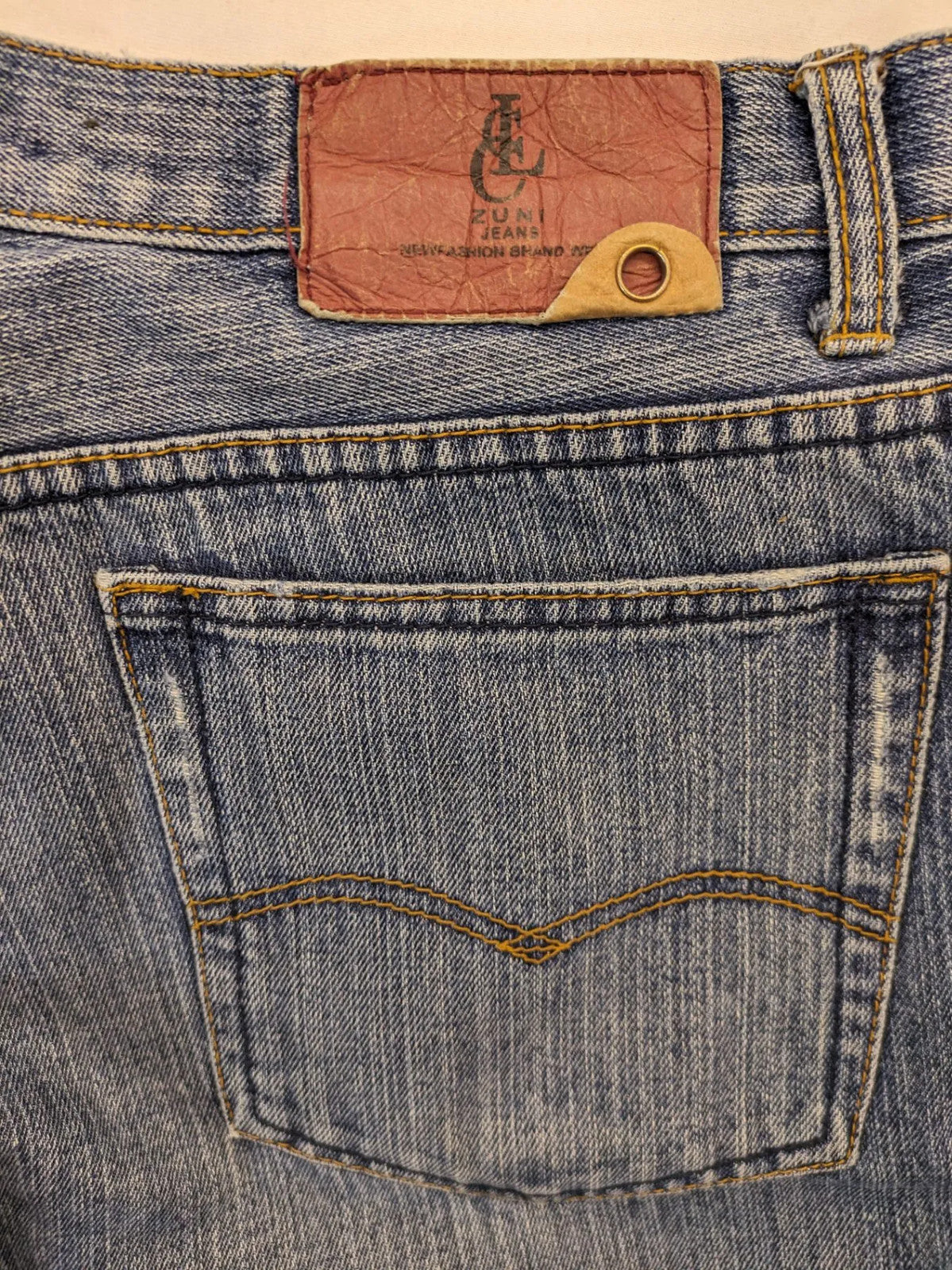 Zuni blue straight jeans 5-pocket design with zipper and decorative rivets.