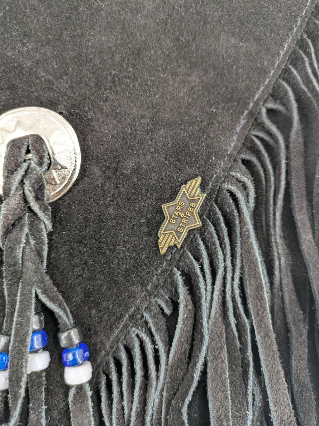 Stars & Stripes black suede fringe vest with silver conchos and beaded tassels.