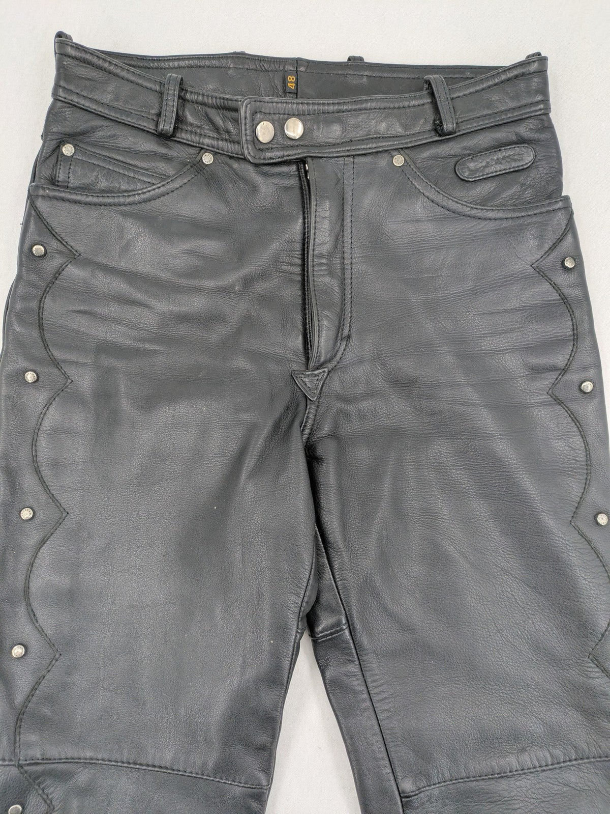 Hein Gericke black leather chaps with studs and wavy decorative seams.