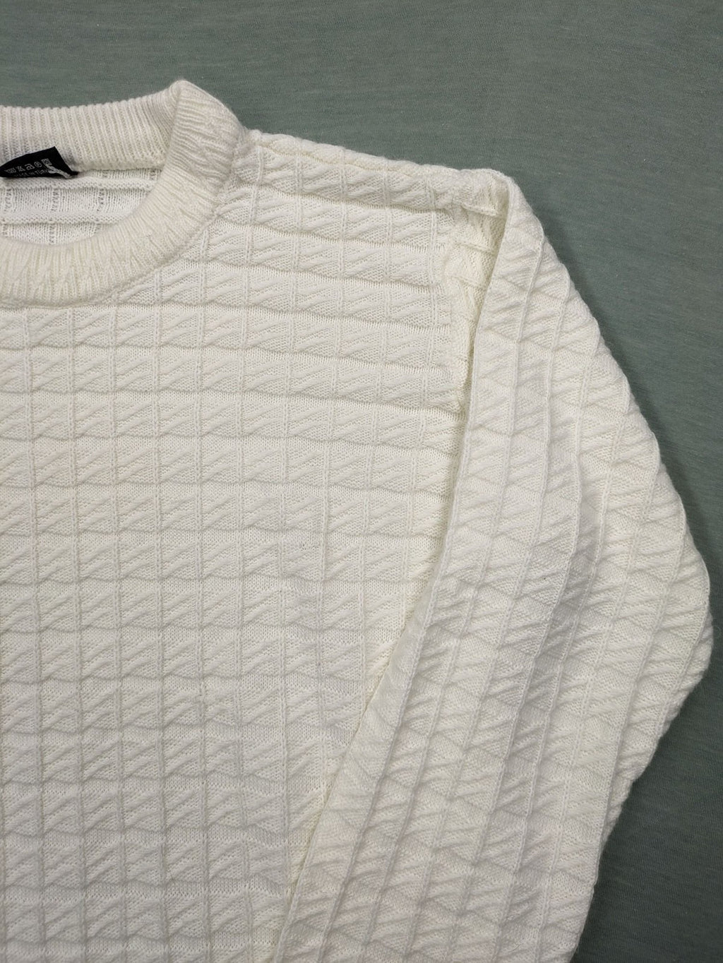 Haskalkan white turtle neck jumper with geometric textured pattern and ribbed cuffs.
