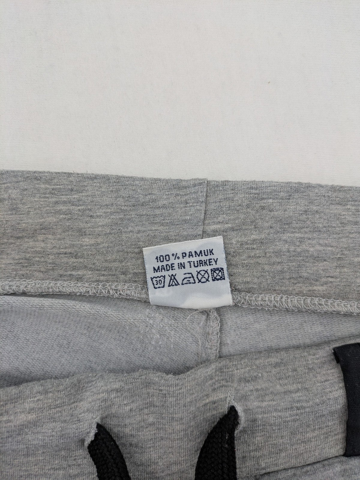 Falconhill grey jogging pants with elastic waistband, drawstring, and stylish black accent pockets.