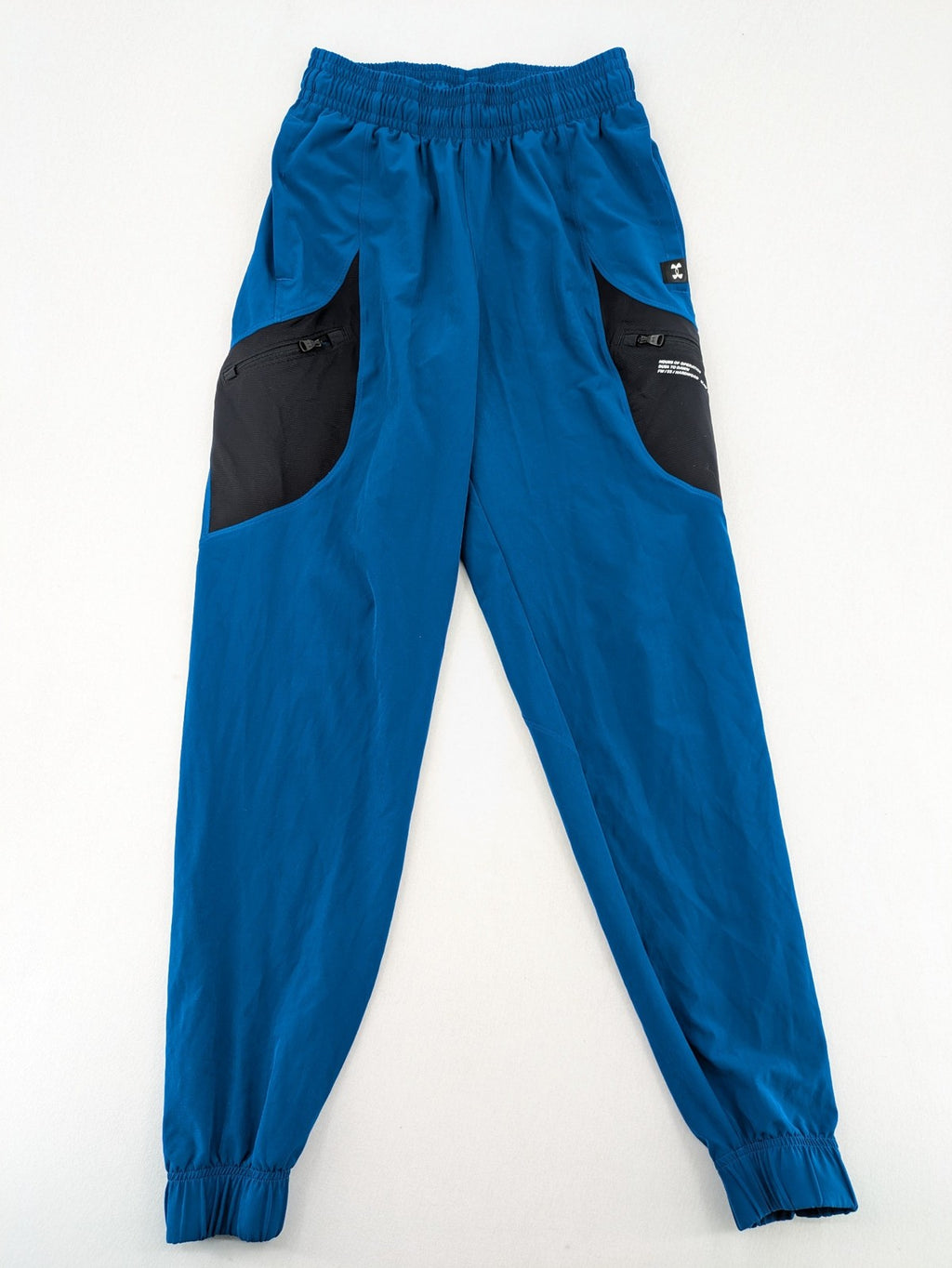 Under Armour blue HeatGear joggers with black accents and zippered cargo pockets.