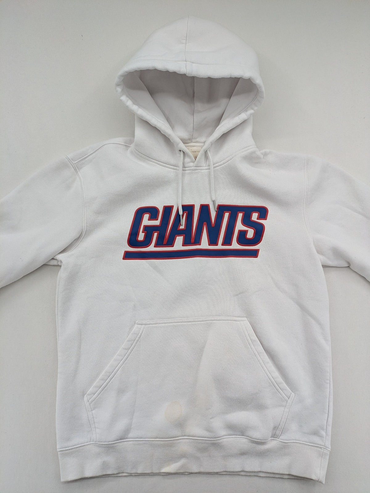 New York white hoodie with raised blue and red "GIANTS" logo and adjustable hood.