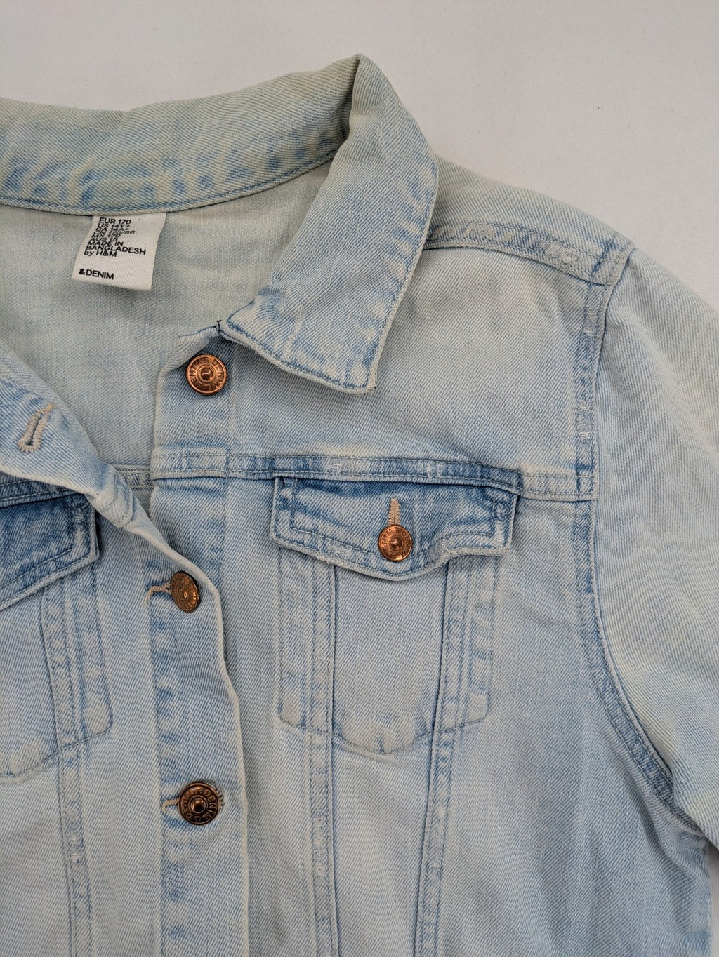 H&M denim jacket light blue classic trucker style with button placket and chest pockets.