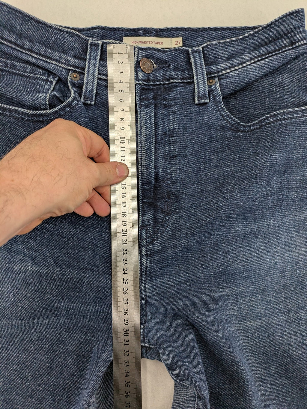 Levi's high waisted taper jeans dark blue 5-pocket design with zipper and stretch material.