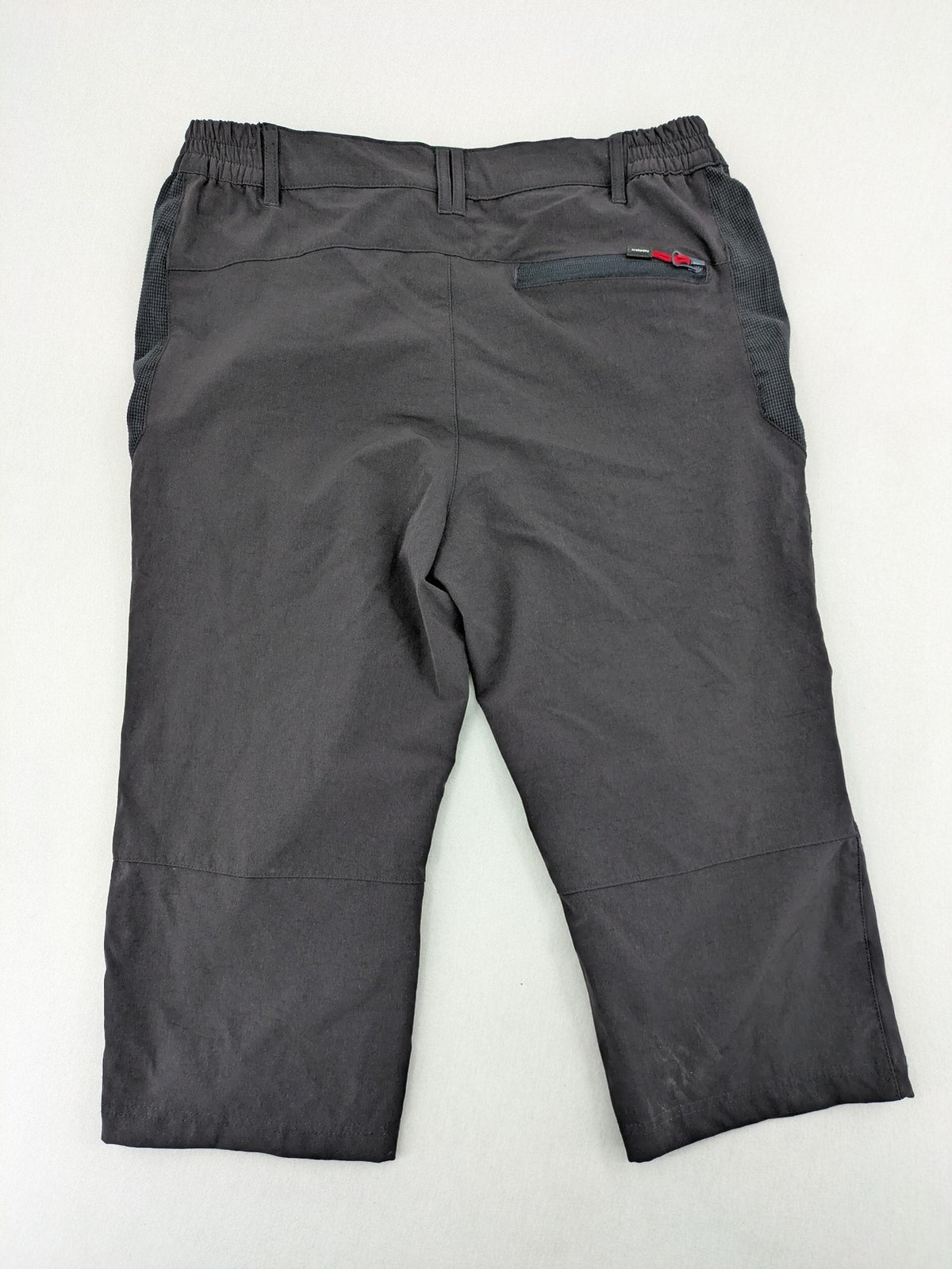 Outdoor black capri pants with elastic waistband and multiple zippered pockets.
