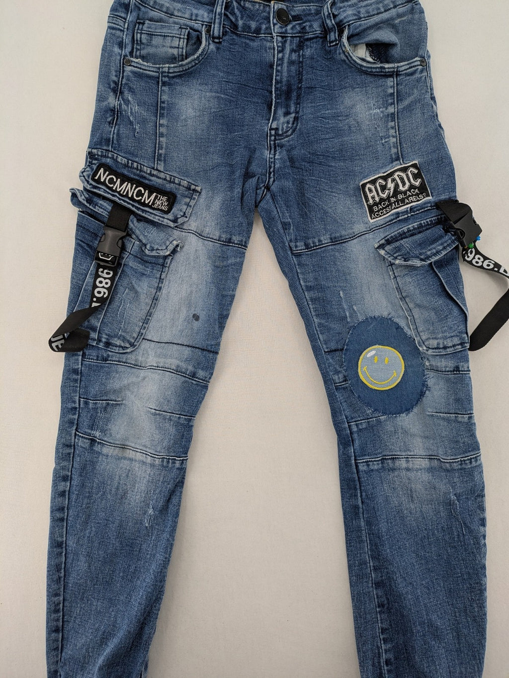 FN.G blue straight jeans with AC/DC patch, smiley face, and elastic jogger cuffs.