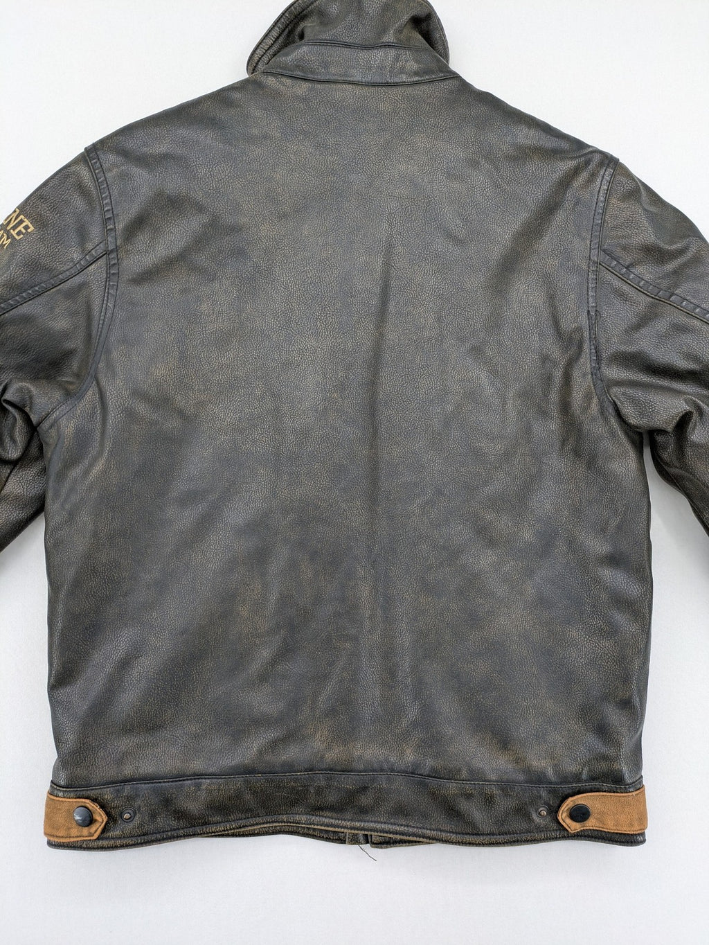 Junge brown bomber jacket with vintage patches and embroidered details in faux leather.