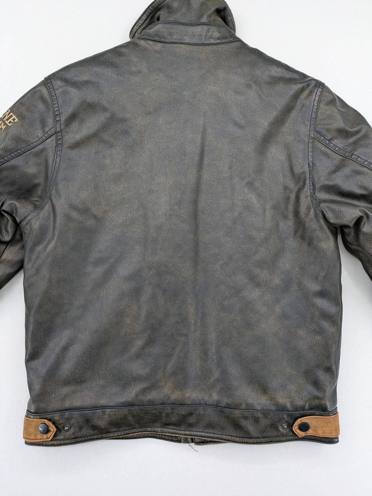 Junge brown bomber jacket with vintage patches and embroidered details in faux leather.