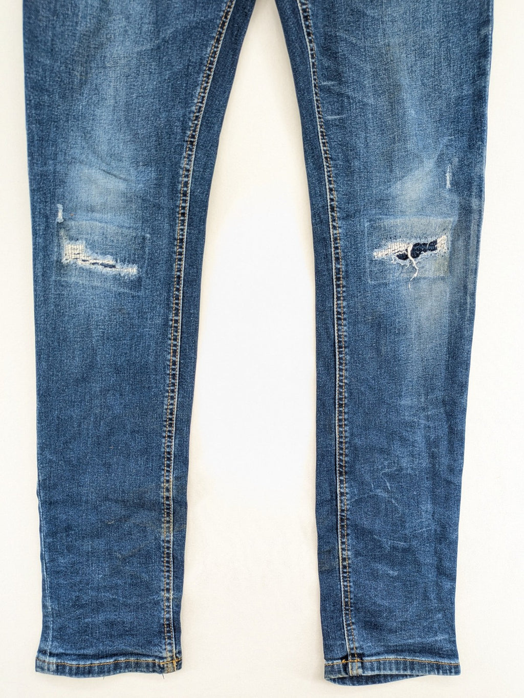 Denim & Co. blue skinny jeans with distressed ripped details and adjustable waistband.
