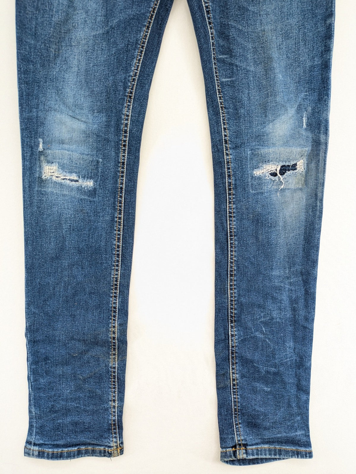 Denim & Co. blue skinny jeans with distressed ripped details and adjustable waistband.