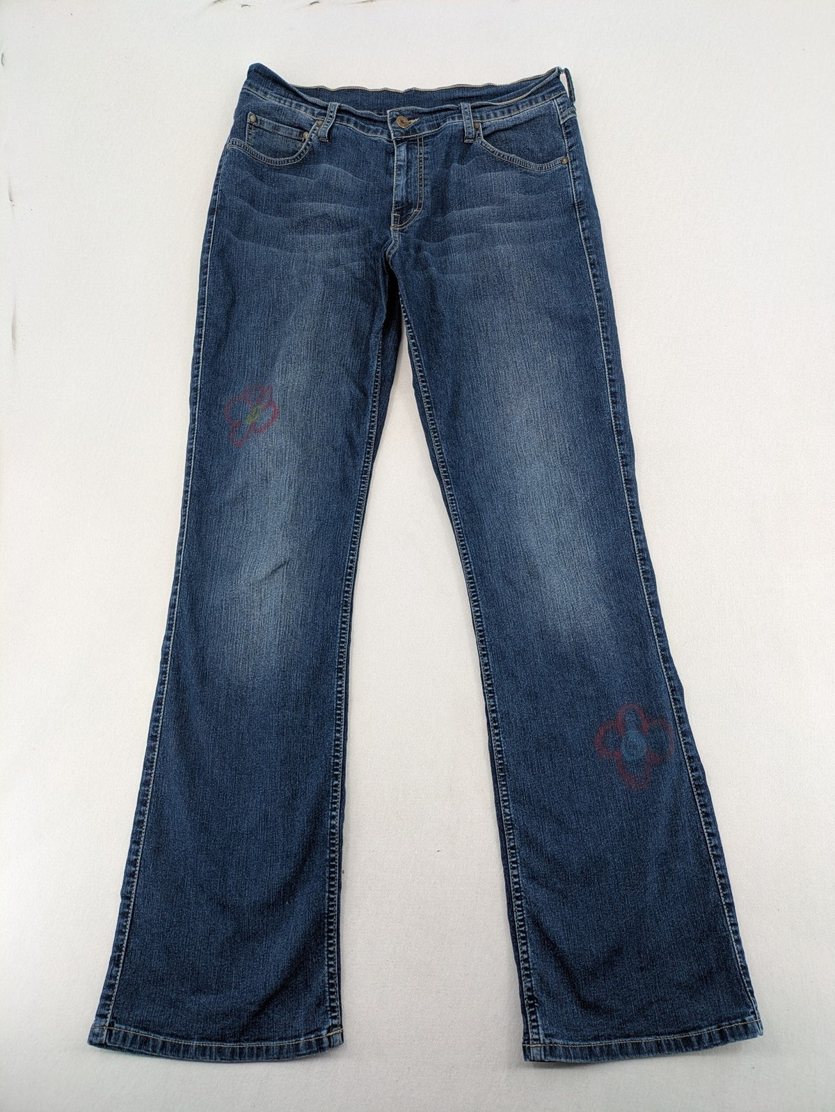 Mustang blue bootcut jeans with custom painted floral designs on both legs.