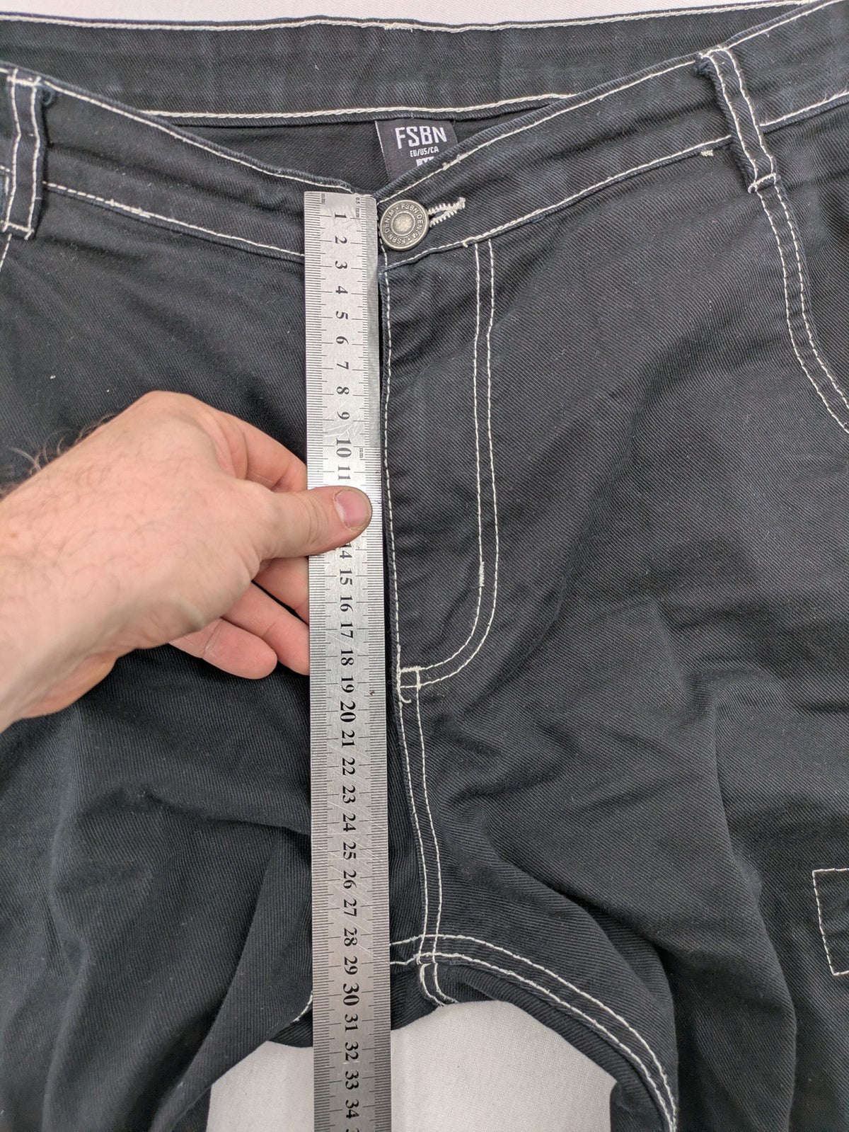 FSBN black baggy cargo pants with white contrast stitching and multiple pockets.