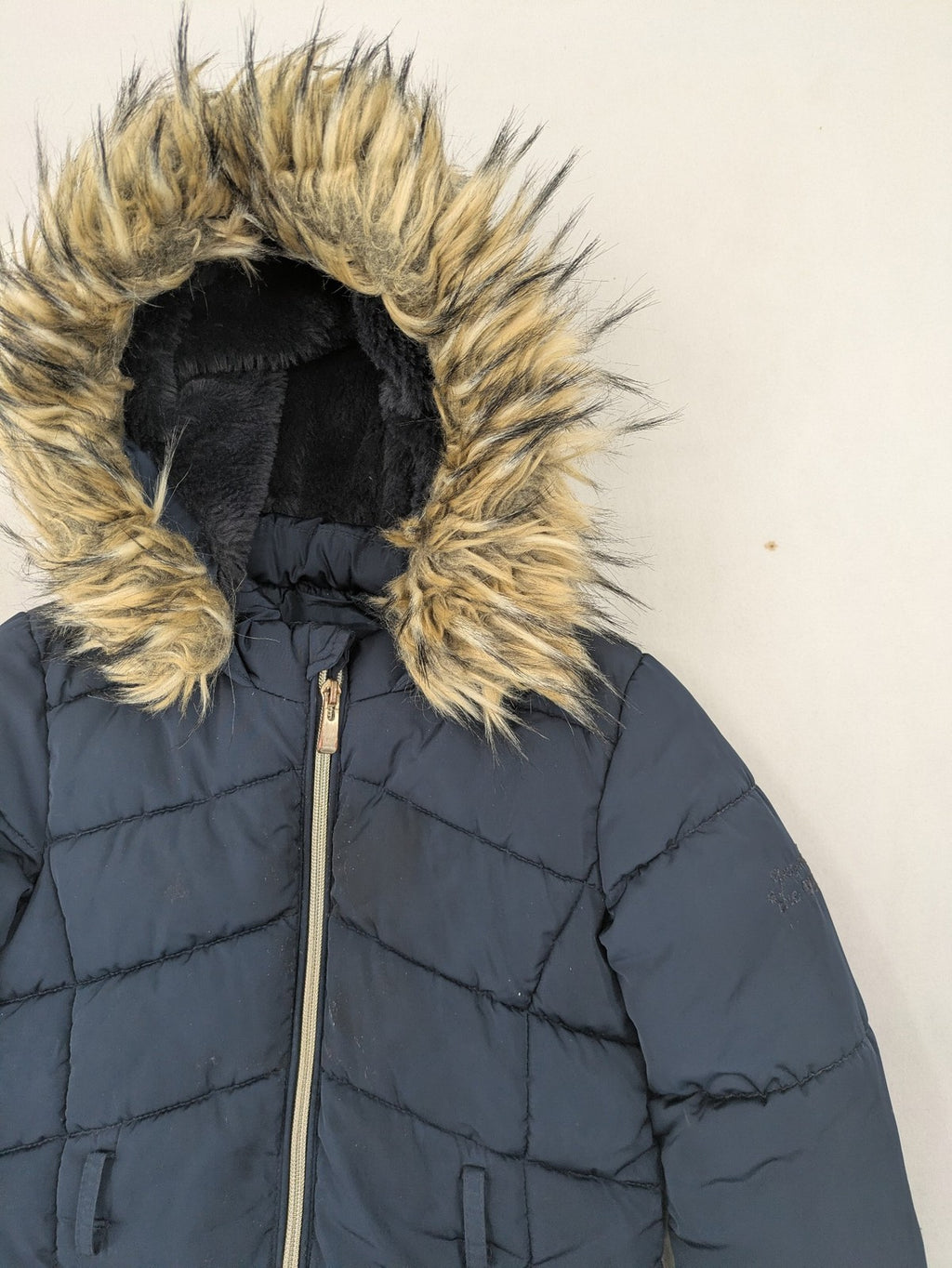 GEF cream coat with quilted design, fleece-lined hood, and faux fur trim.