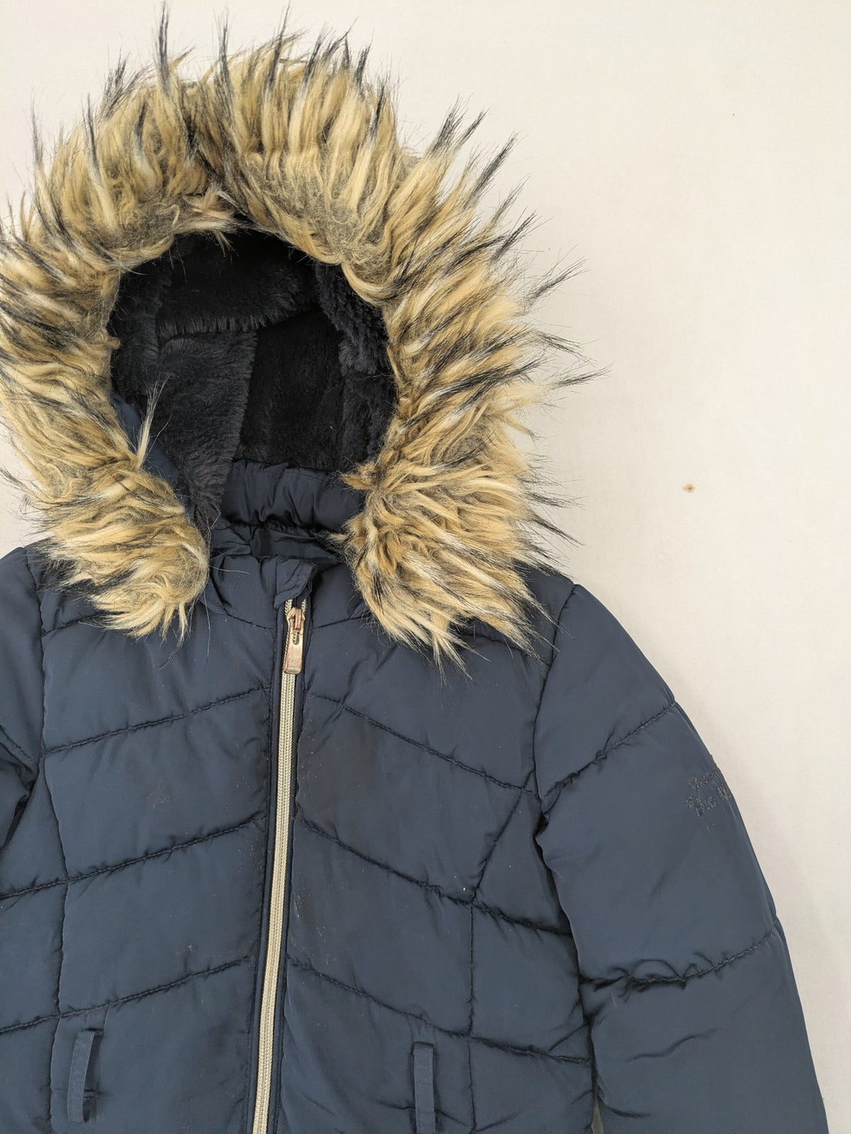 GEF cream coat with quilted design, fleece-lined hood, and faux fur trim.