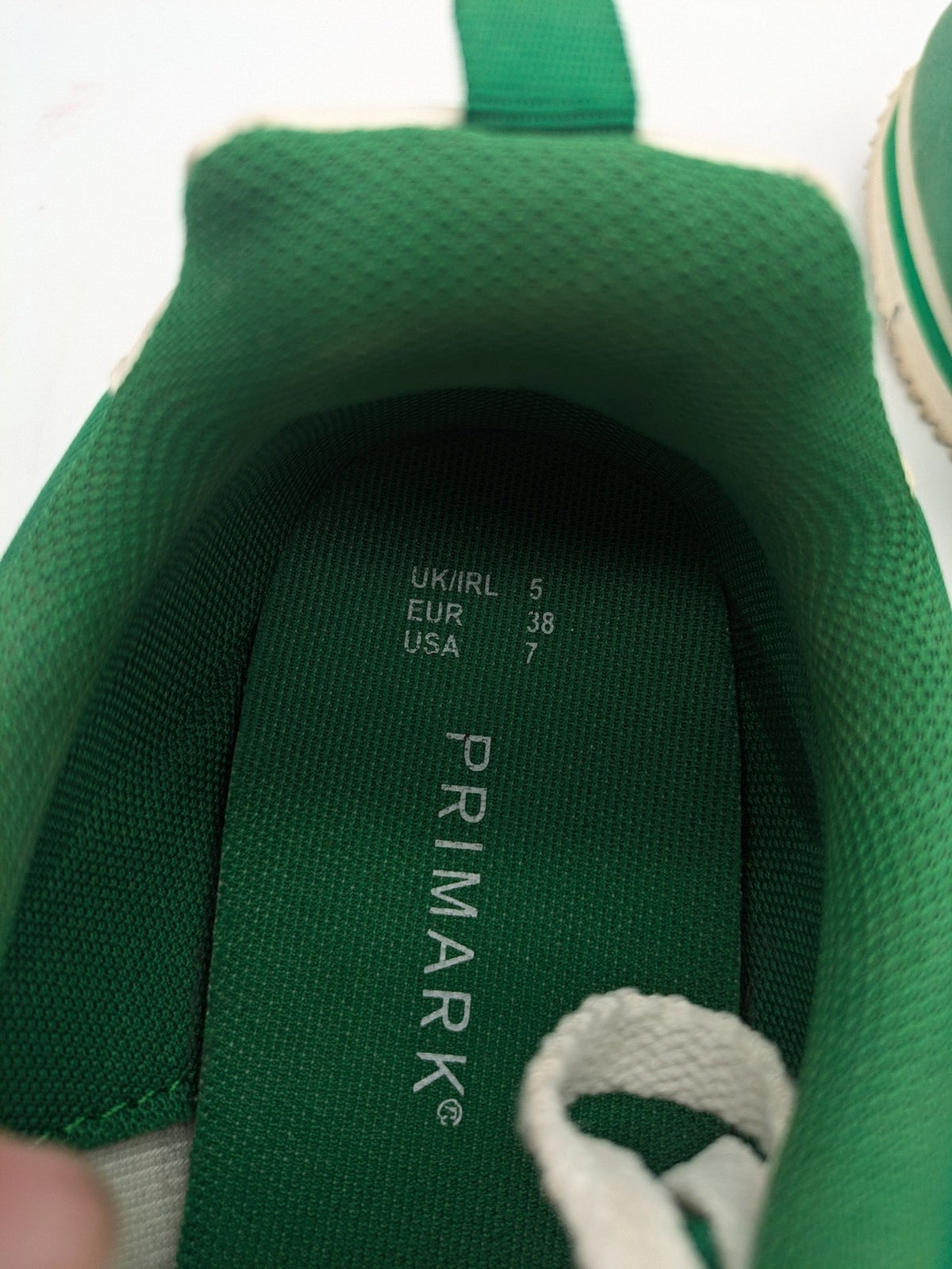 Primark green and white retro sneakers with classic lace-up design and textured rubber sole.