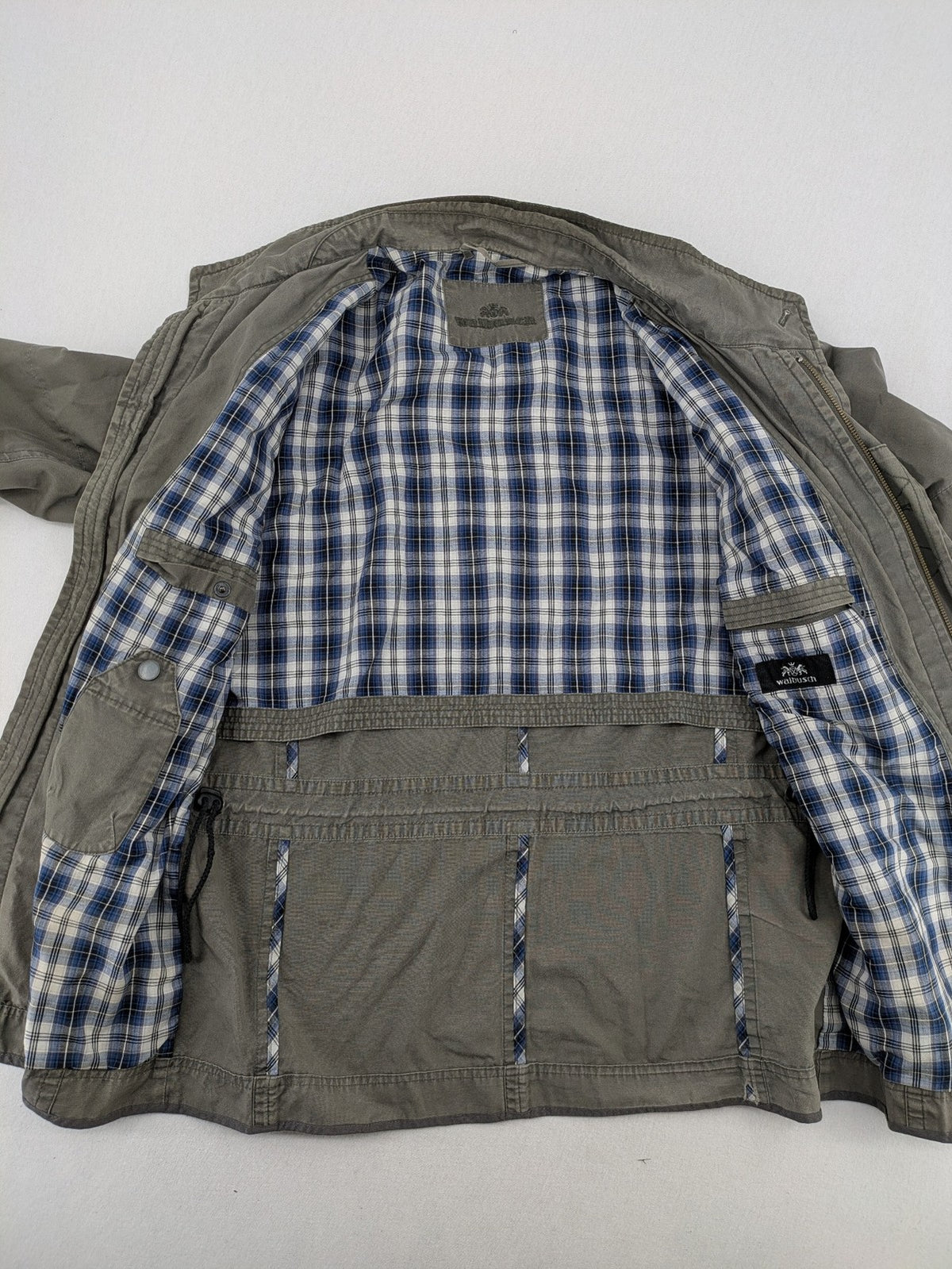 Walbusch khaki military jacket with checkered blue-white lining and multiple pockets.
