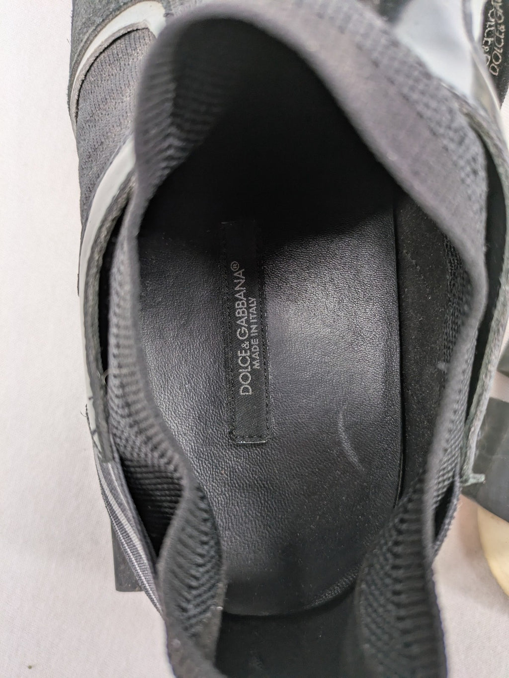 Dolce & Gabbana black sneakers with logo laces and segmented sole design.