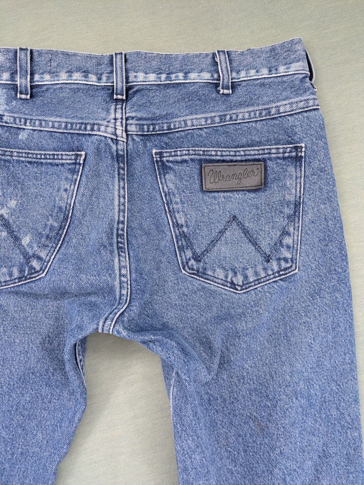 Wrangler blue straight jeans with button fly and classic 5-pocket design.
