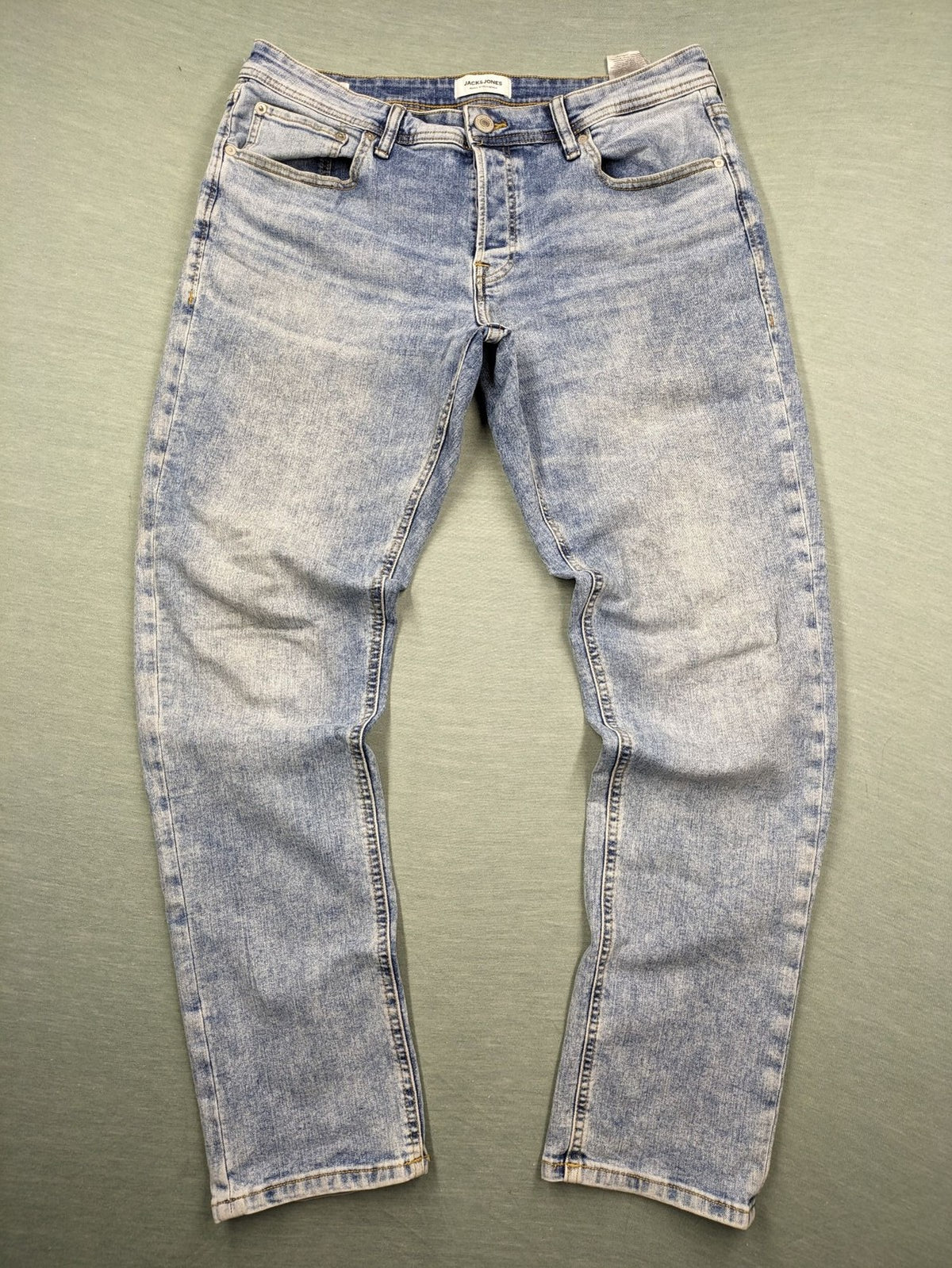 Jack & Jones blue slim fit jeans with button fly and light wash denim texture.