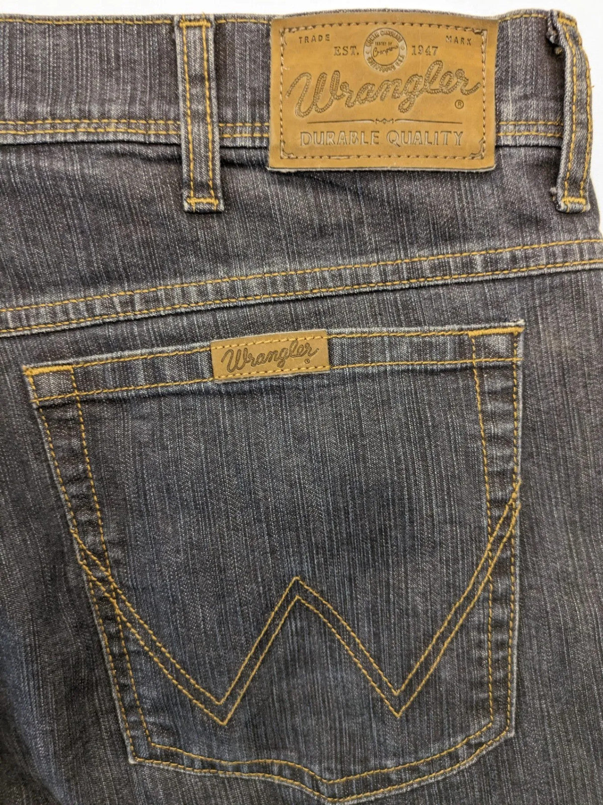 Wrangler straight jeans dark blue wash 5-pocket design with zipper, durable cotton blend.