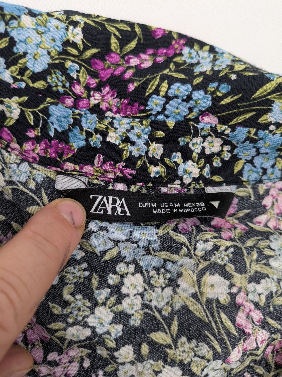 Zara multi-coloured floral mini dress with classic collar and button placket on black background.