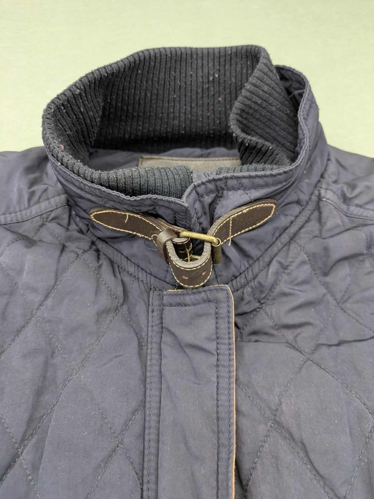 Massimo Dutti black quilted jacket with contrasting brown trim and ribbed side inserts.