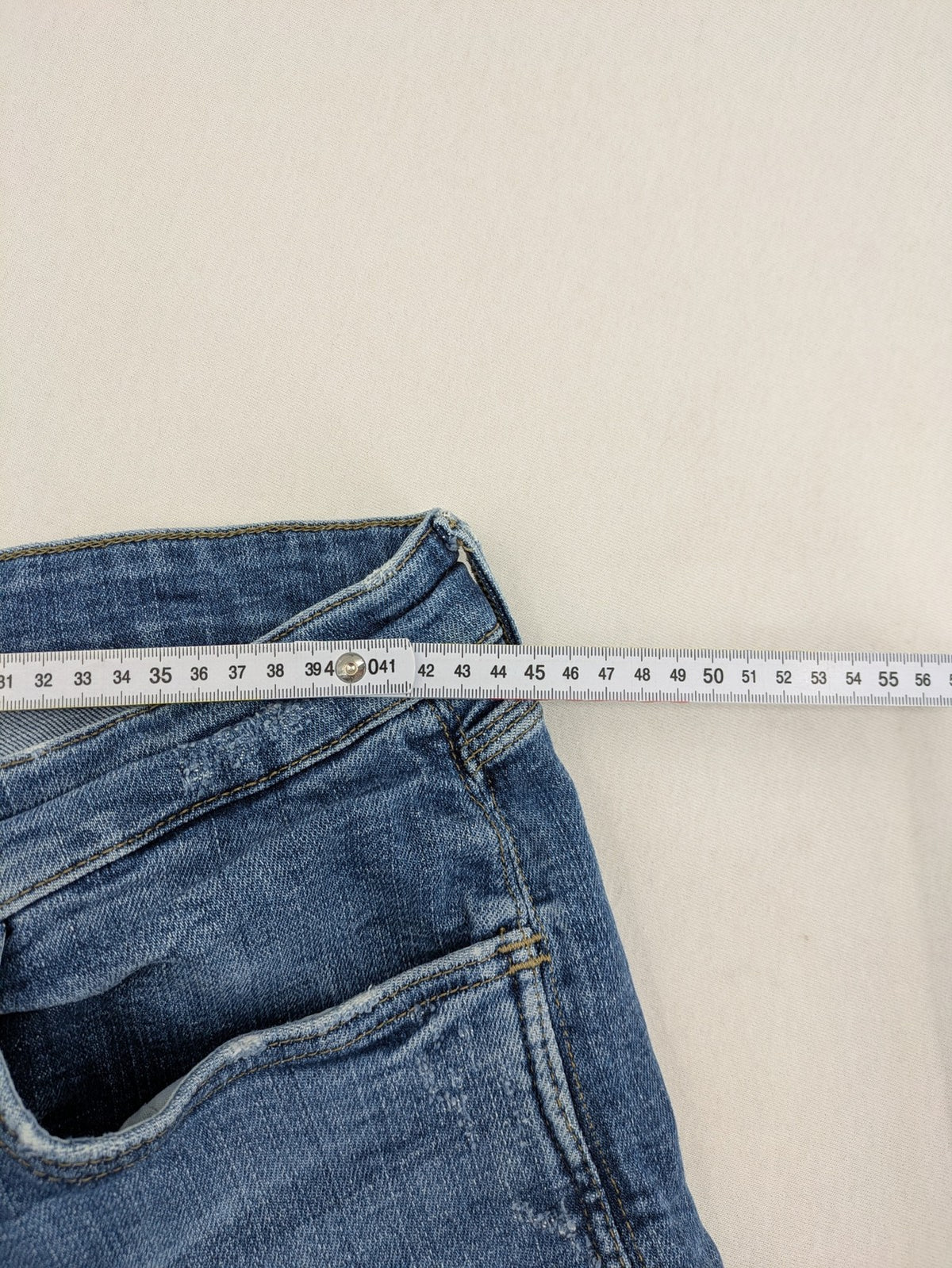 Zara blue straight jeans with distressed ripped knees and button-fly closure.
